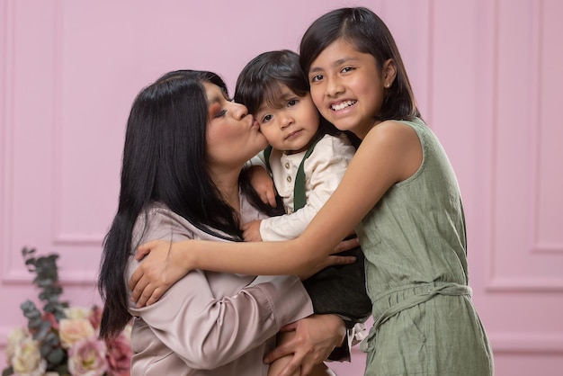 Mexican mother with hugging and laughing with her two children