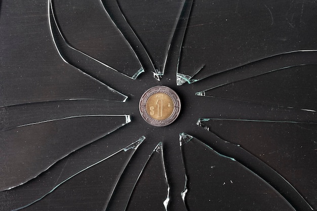 Mexican peso coin on broken glass Inflation concept