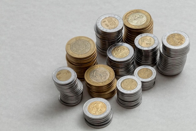 Mexican pesos coins stacked by denominations on a table