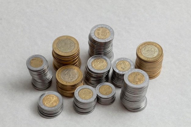 Mexican pesos coins stacked by denominations on a table