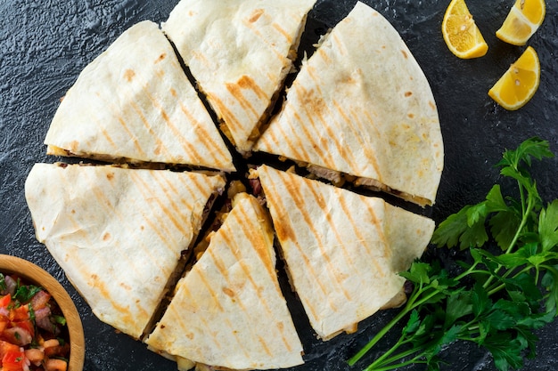 Mexican Quesadilla with chicken, corn, red beans, cheese and peppers and salsa. Selective focus.Top view.