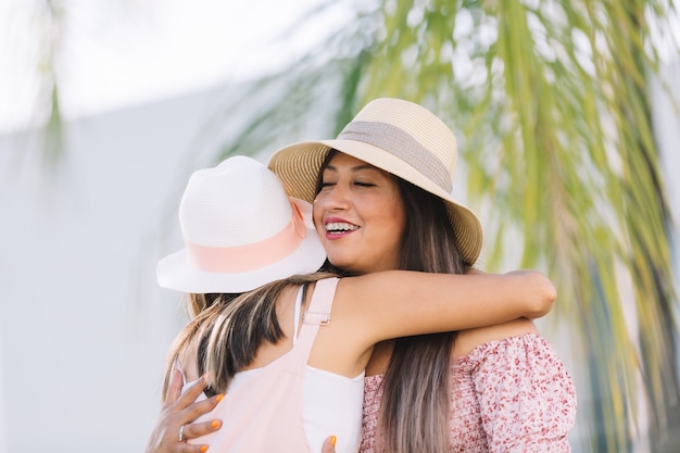 Mexican sisters hugging and smiling on summer vacation