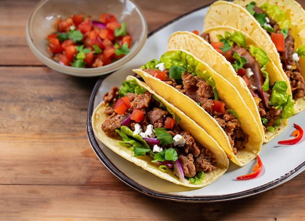 Mexican Tacos With Beef In Tomate And Salad On Wooden Table