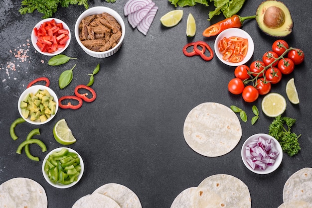 Mexican tacos with beef, tomatoes, avocado, onion and salsa sauce