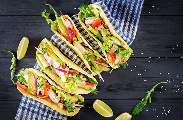 Mexican tacos with chicken meat, avocado, tomato, cucumber and red onion.