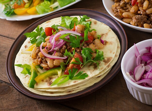 Mexican tacos with meat, beans and salsa