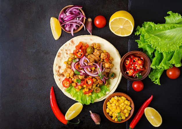 Mexican tacos with meat, corn and olives on dark background. Top view