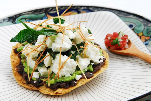 Mexican toast with beans guacamole pico de gallo and fresh cheese typical Mexican food