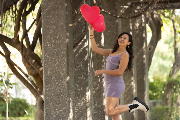 Mexican woman holding red balloon happy expression outdoors self love empowerment