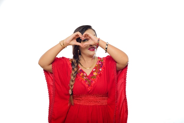 Mexican woman making a heart symbol with her hands.