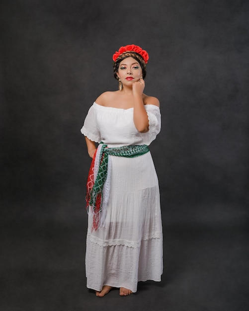 Mexican woman with white dress and scarf with the colors of the Mexican flag