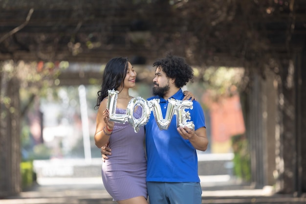 Mexican young couple holding love balloon