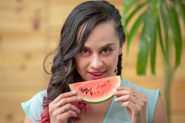 Mexican young woman summer portrait eating a watermelon slice