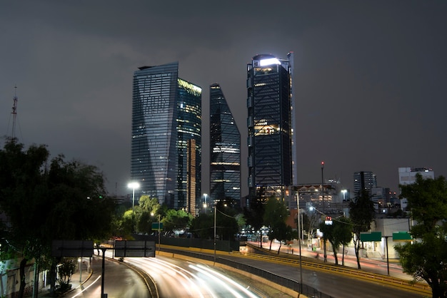 Mexico City buildings on a rainy day and an avenue at the bottom with a sweep of lights from cars