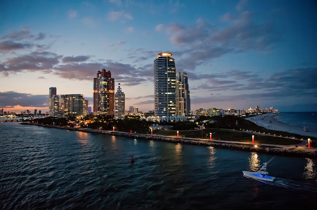 Miami skyscrapers with blue cloudy sky,white boat next to Miami downtown, Aerial view