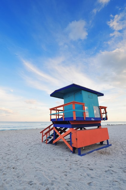 Miami South Beach sunset with lifeguard tower and coastline with colorful cloud and blue sky.