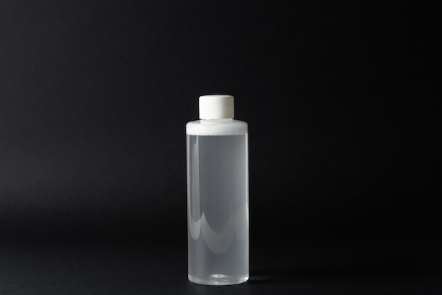 Micellar water bottle on black background