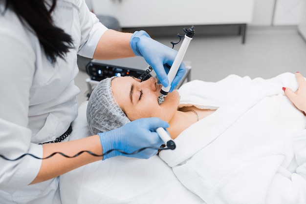 Microcurrent therapy procedure for facelift in a cosmetology clinic.