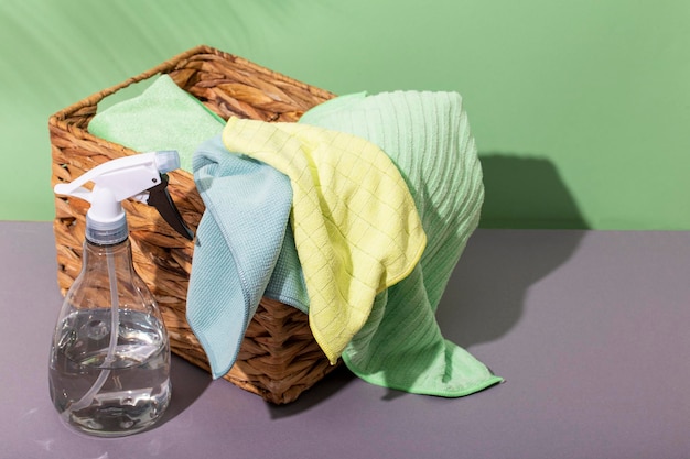 Microfiber cloths for cleaning and a spray bottle with clean water Tools for eco friendly cleaning without household chemicals on a green background