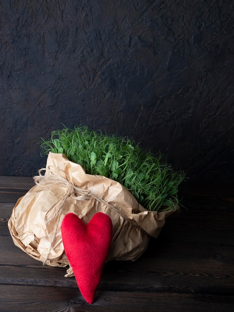 Microgreens in a kraft bag with a red heart symbolizing health and life an ecofriendly food supplement for proper nutrition and improving the quality of life