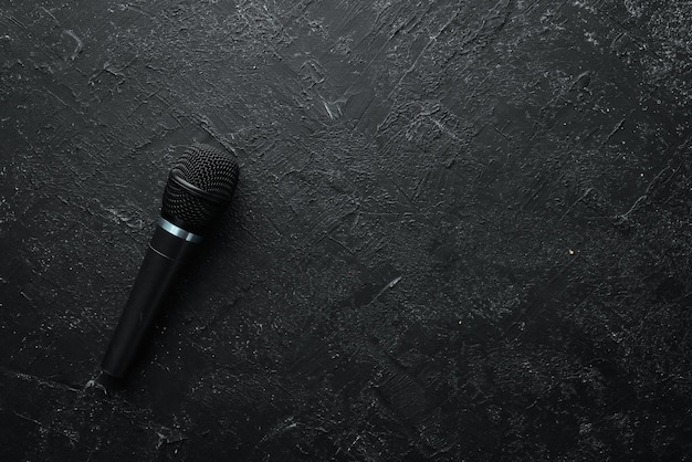 Photo microphone on black stone table studio top view free space for text copy space