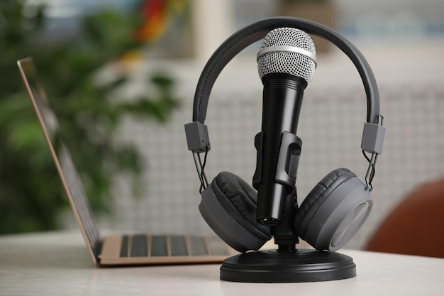 Microphone modern headphones and laptop on table indoors