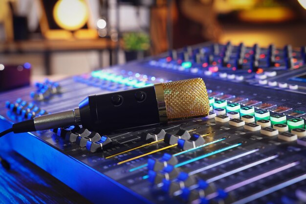 Photo microphone on professional mixing console in radio studio closeup