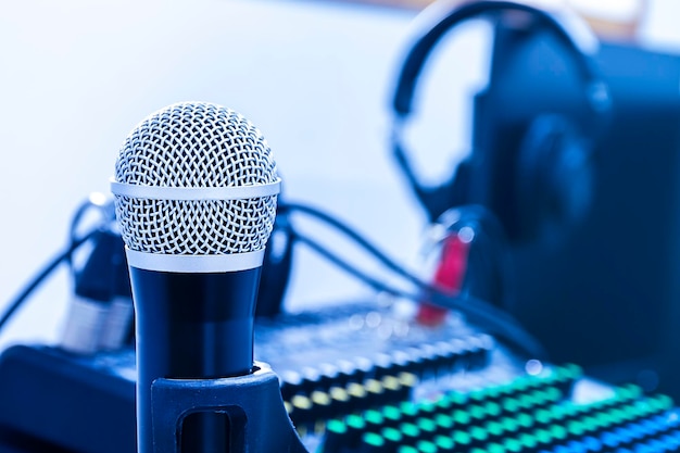 Microphone on tripod with mixer background in sound control room