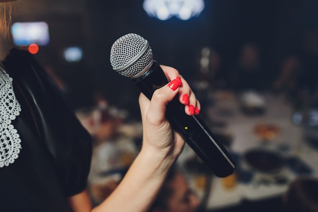 Microphone and unrecognizable female singer close up