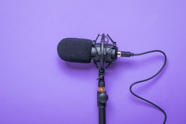 Microphone with a cord screwed to the stand on a purple surface