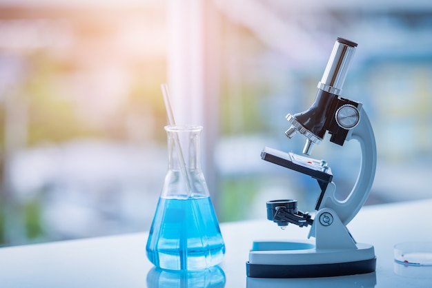 Microscope and Beaker on table in Laboratory