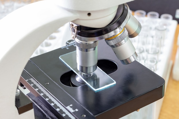 Microscope in a medical laboratory against the background of test tubes