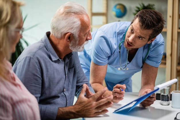 Photo mid adult doctor having consultations with mature couple and explaining them their medical test results