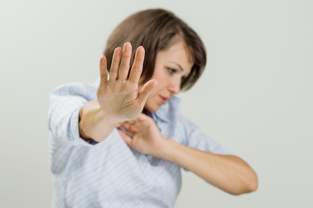 Mid adult emotional woman showing stop sign.