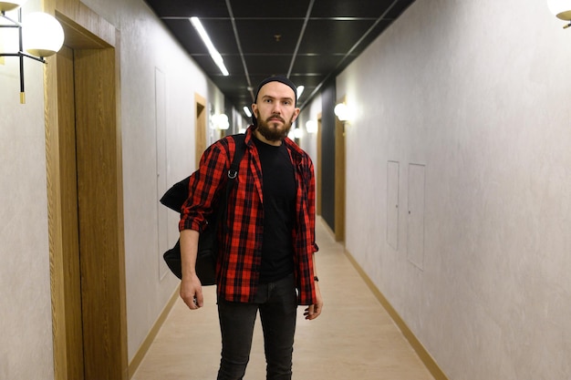 Mid adult man arriving to hotel and going to the room while pulling his suitcase through the lobby