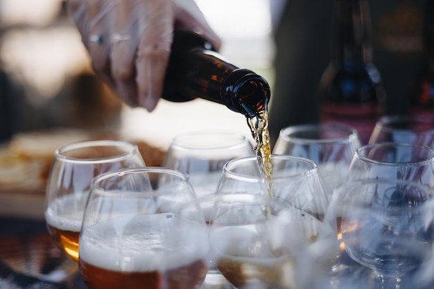 Mid section of bartender pouring beer in a glass at bar counter