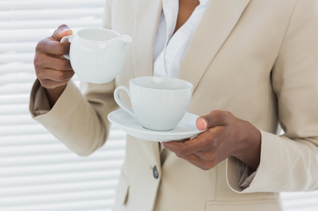 Mid section of elegant businesswoman with tea cup