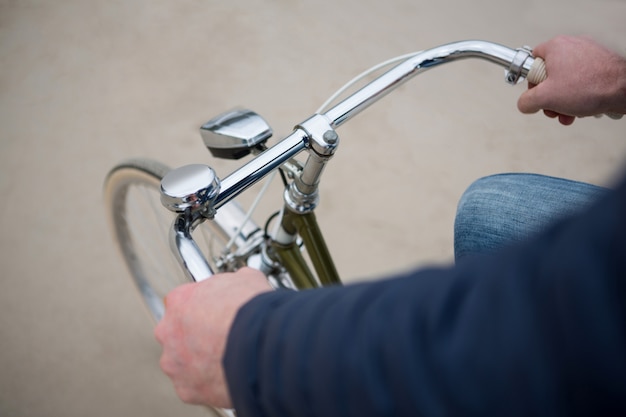 Mid section of man riding bicycle on beach