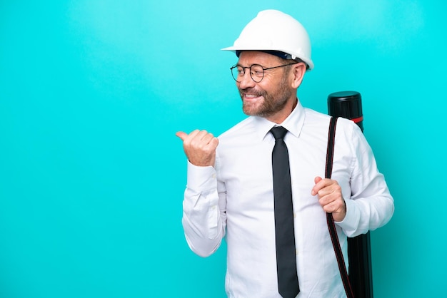 Middle age architect man with helmet and holding blueprints