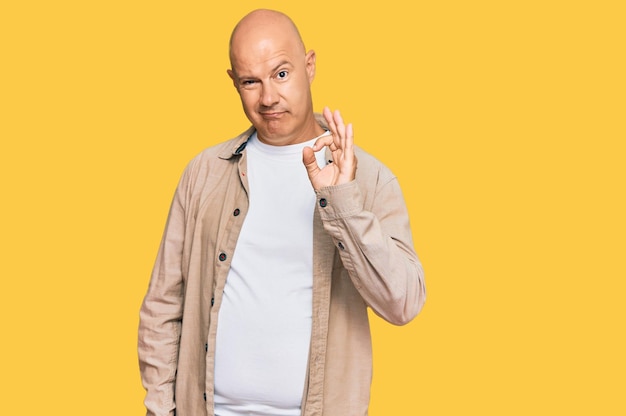 Middle age bald man wearing casual clothes smiling positive doing ok sign with hand and fingers successful expression