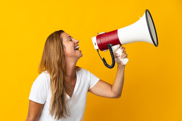 Middle age brazilian woman isolated shouting through a megaphone to announce something