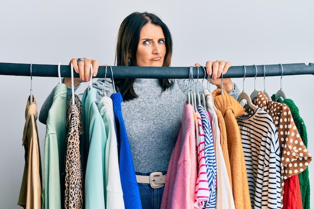 Middle age brunette woman working as professional personal shopper skeptic and nervous frowning upset because of problem negative person