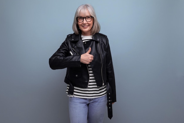 Middle age business s mature woman in gray hair in a stylish youth look looks cool on a blue