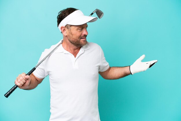 Photo middle age caucasian golfer player man isolated on blue background with surprise expression while looking side