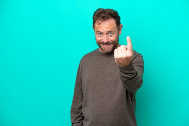 Middle age caucasian man isolated on blue background doing coming gesture