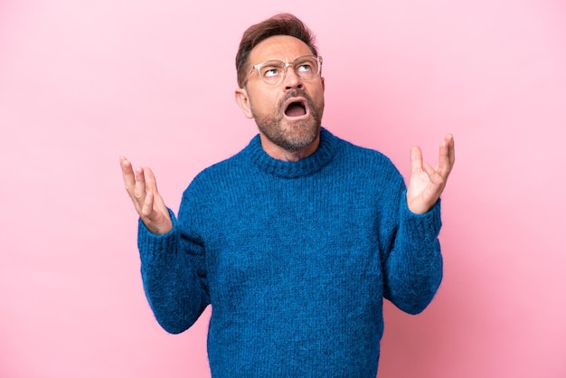 Middle age caucasian man isolated on pink background stressed overwhelmed