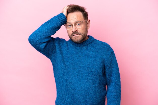 Middle age caucasian man isolated on pink background with an expression of frustration and not understanding