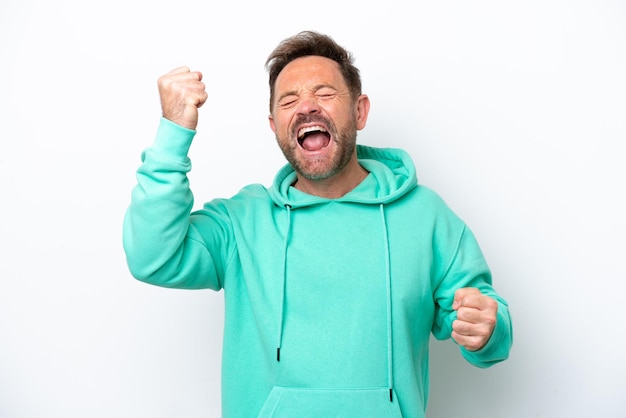 Middle age caucasian man isolated on white background celebrating a victory