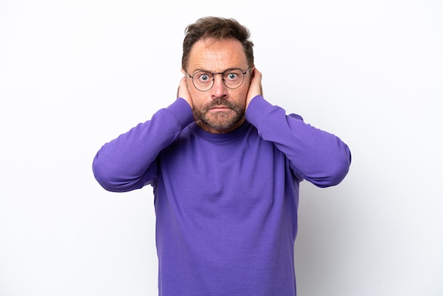 Middle age caucasian man isolated on white background frustrated and covering ears