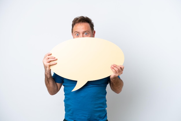 Middle age caucasian man isolated on white background holding an empty speech bubble hiding behind it hiding behind it